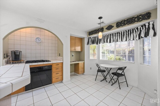 7601 Live Oak Way, Bakersfield, CA 93308 - kitchen with black appliances, tile countertops, arched walkways, light tile patterned floors, and hanging light fixtures