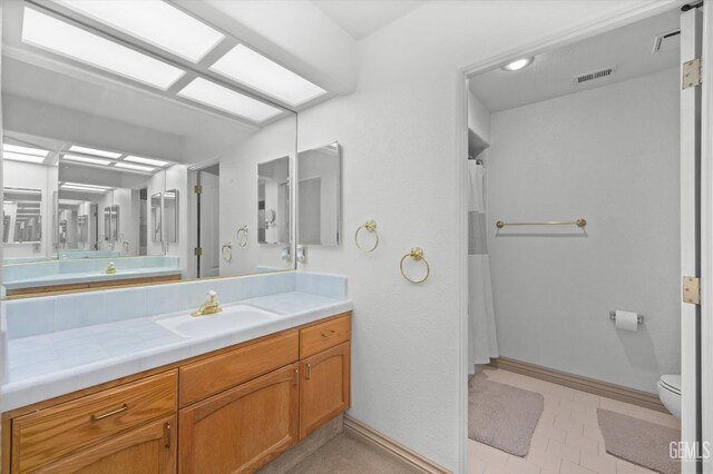 7601 Live Oak Way, Bakersfield, CA 93308 - bathroom featuring toilet, vanity, baseboards, and a shower with curtain