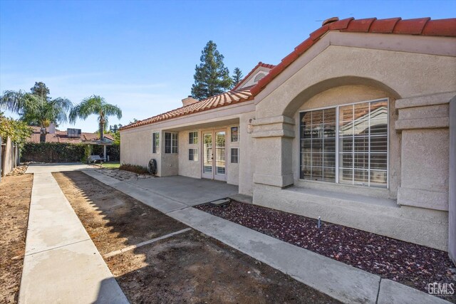 7601 Live Oak Way, Bakersfield, CA 93308 - view of exterior entry featuring french doors, a tile roof, and stucco siding