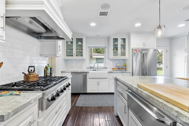 kitchen with stainless steel appliances, premium range hood, sink, and white cabinets