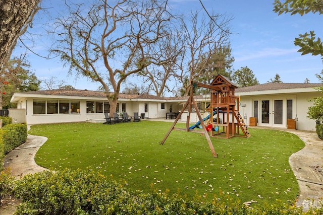 view of yard featuring french doors, a playground, and a patio area