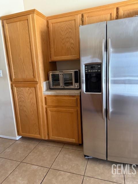 10011 Grand View Summit Dr, Bakersfield, CA 93311 - kitchen with stainless steel fridge, light tile patterned floors, and light countertops