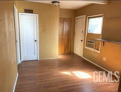 spare room with baseboards, wood finished floors, and visible vents