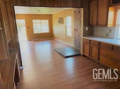 kitchen with light countertops, baseboards, brown cabinetry, and wood finished floors