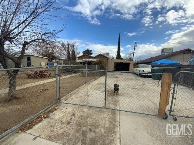 exterior space featuring fence, a gate, and concrete driveway