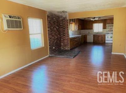 kitchen with baseboards, dishwashing machine, white range, dark wood-type flooring, and light countertops