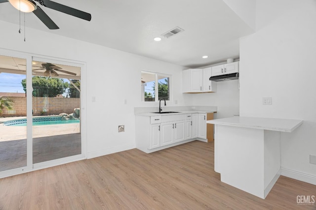 1317 Canyon Ct, Bakersfield, CA 93307 - kitchen featuring a ceiling fan, a sink, light countertops, light wood-style floors, and recessed lighting