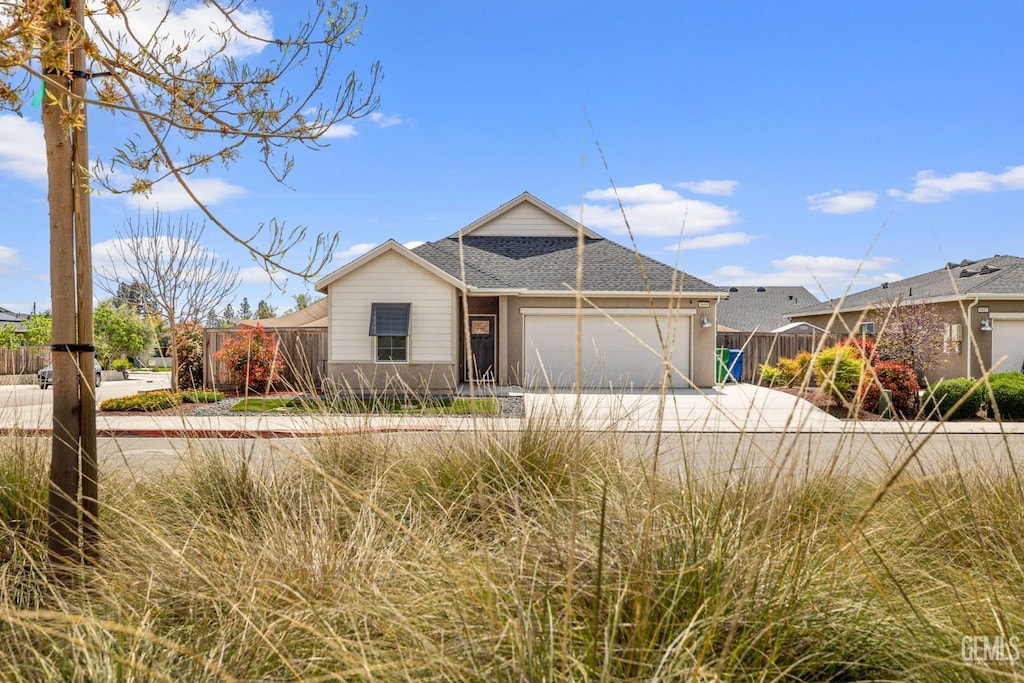 single story home featuring fence, driveway, a shingled roof, and a garage