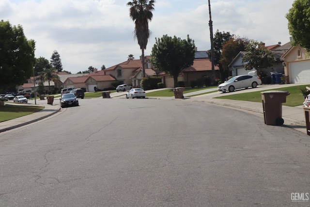 view of street with curbs, sidewalks, and a residential view