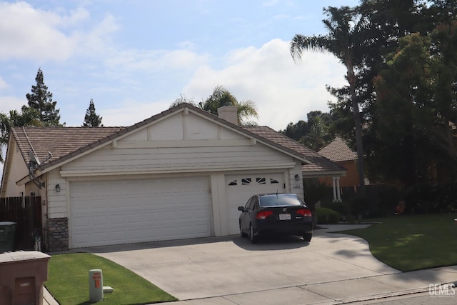 view of front of house featuring a chimney, a tiled roof, a garage, driveway, and stone siding