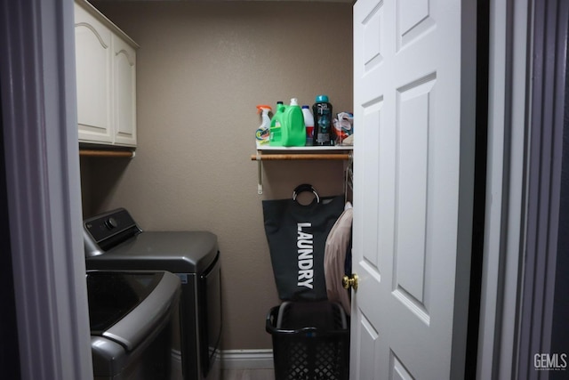 laundry area with baseboards, cabinet space, and washer and clothes dryer