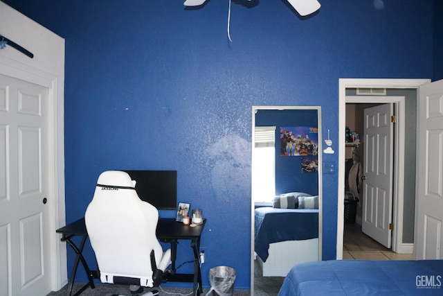 bedroom with tile patterned floors, visible vents, and ceiling fan