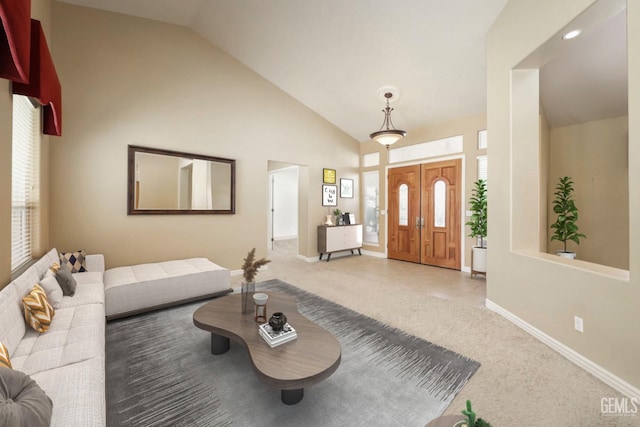 carpeted entrance foyer with high vaulted ceiling