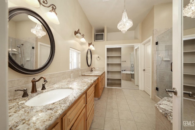 bathroom featuring walk in shower, tile patterned flooring, vanity, and an inviting chandelier