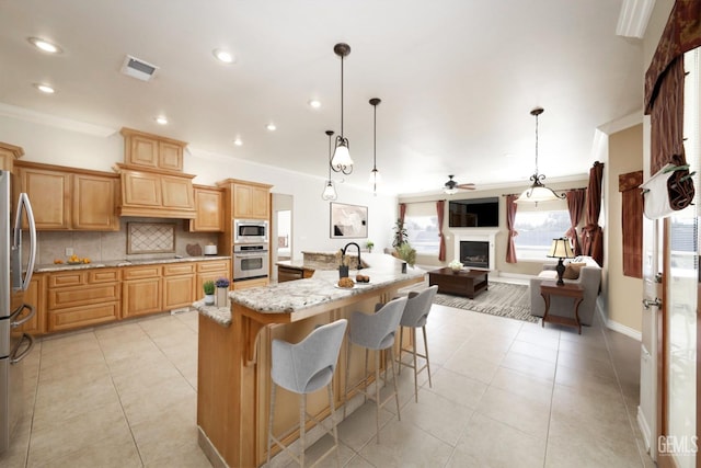 kitchen with a kitchen bar, a large island, stainless steel appliances, and decorative light fixtures