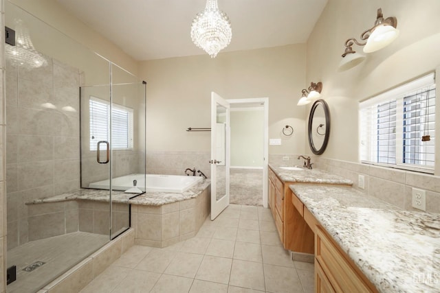 bathroom featuring tile patterned floors, separate shower and tub, vanity, and an inviting chandelier