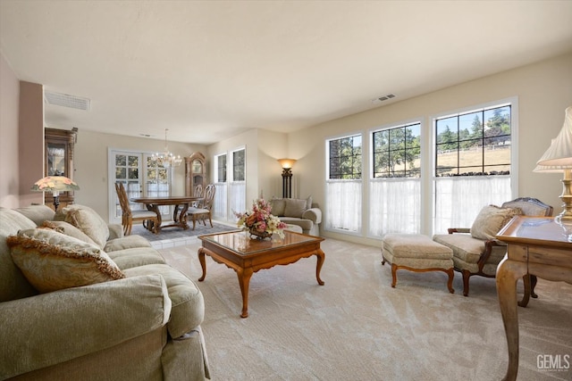 carpeted living room with an inviting chandelier