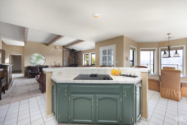 kitchen featuring tile countertops, green cabinets, and black electric cooktop