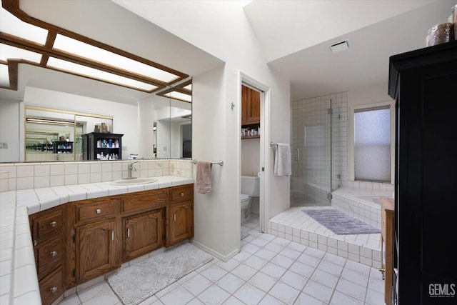 bathroom featuring tile patterned flooring, vanity, toilet, and a shower with shower door