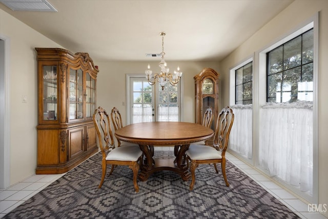 tiled dining space with french doors and a chandelier