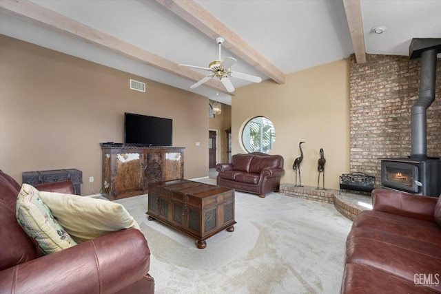 carpeted living room with lofted ceiling with beams, a wood stove, and ceiling fan