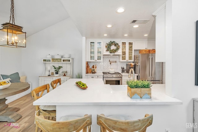 kitchen with visible vents, recessed lighting, backsplash, white cabinetry, and high quality appliances