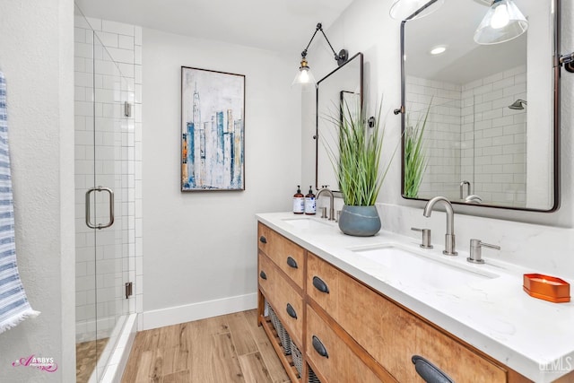 full bath with a shower stall, wood finished floors, and a sink