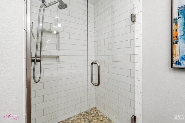 full bathroom featuring a textured wall and a stall shower