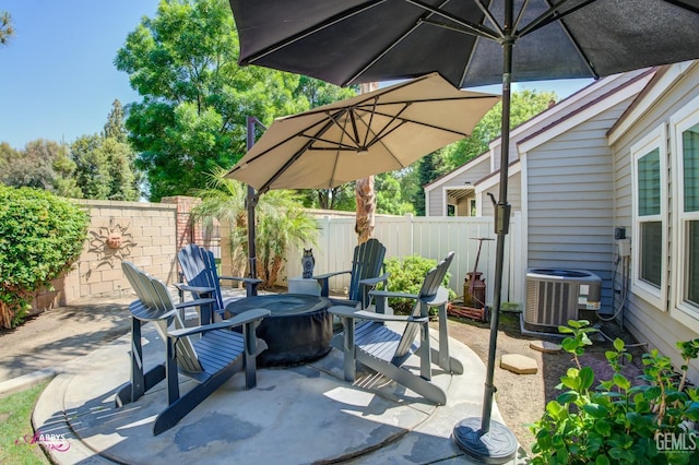 view of patio / terrace featuring a fenced backyard, central AC unit, and an outdoor fire pit