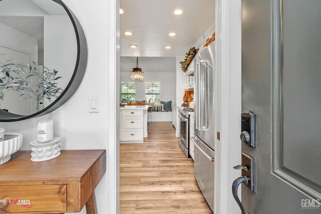 interior space with recessed lighting, stainless steel appliances, light countertops, light wood-style flooring, and white cabinetry