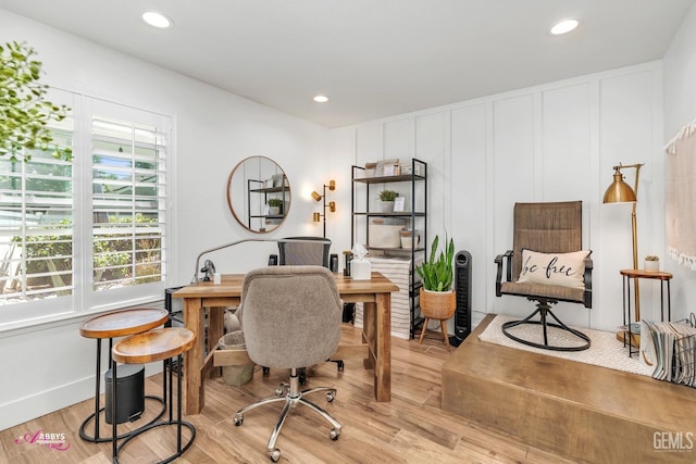 office space featuring recessed lighting, a decorative wall, and light wood-style flooring