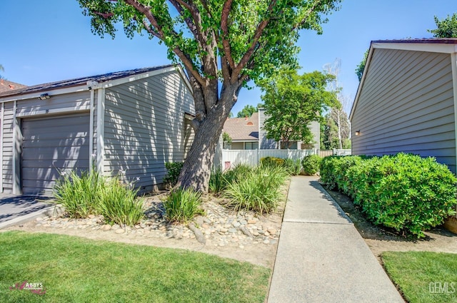 view of side of property featuring fence and a garage