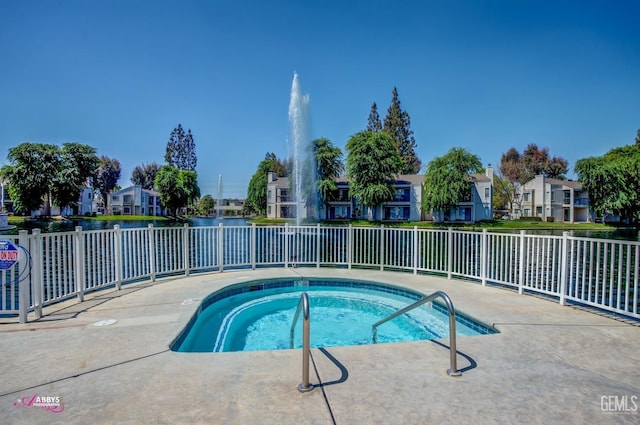 view of pool with a residential view, a hot tub, and fence