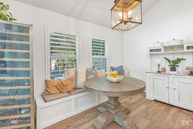 dining space with light wood-style flooring, breakfast area, and an inviting chandelier
