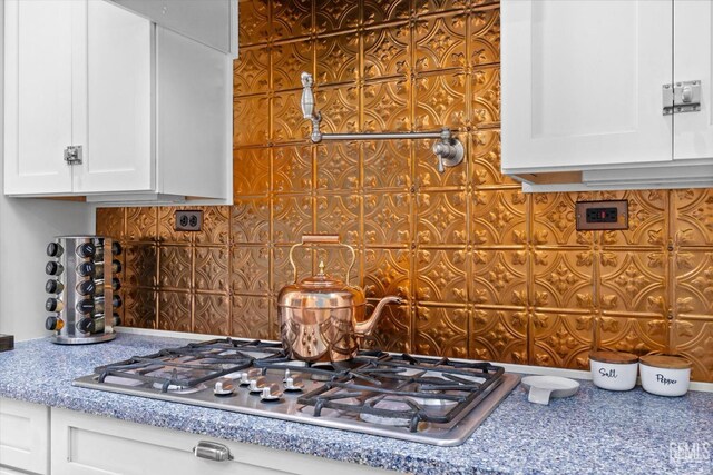 501 Reed St, Bakersfield, CA 93314 - kitchen view of stainless steel gas cooktop, white cabinetry, and tasteful backsplash