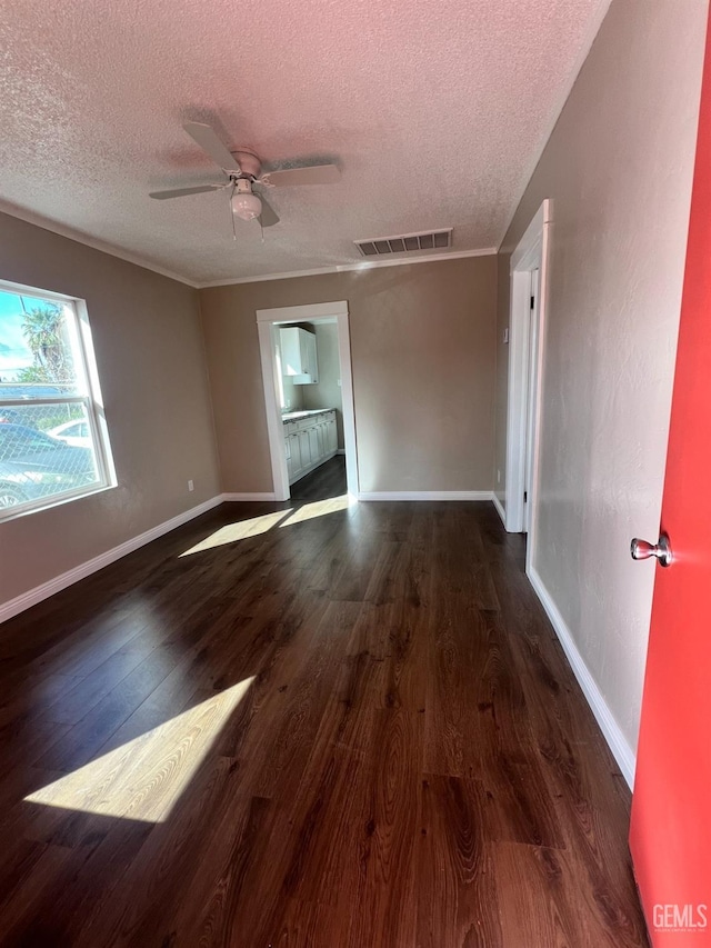 unfurnished room with visible vents, ceiling fan, a textured ceiling, wood finished floors, and baseboards