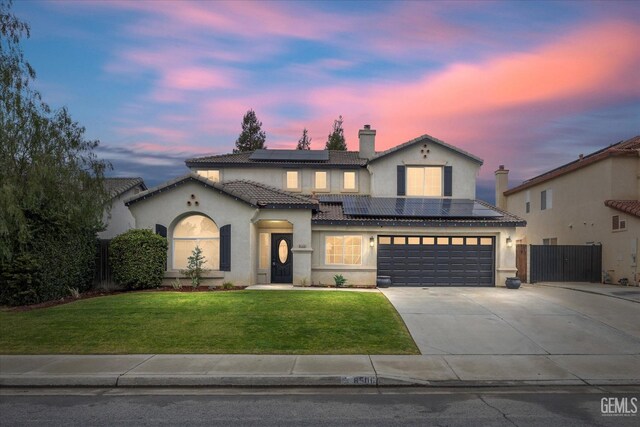 view of front of house with a garage, a front lawn, and solar panels