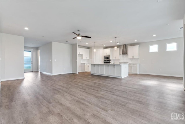 11001 Arundel Way, Bakersfield, CA 93311 - unfurnished living room featuring plenty of natural light, recessed lighting, baseboards, and light wood-style flooring