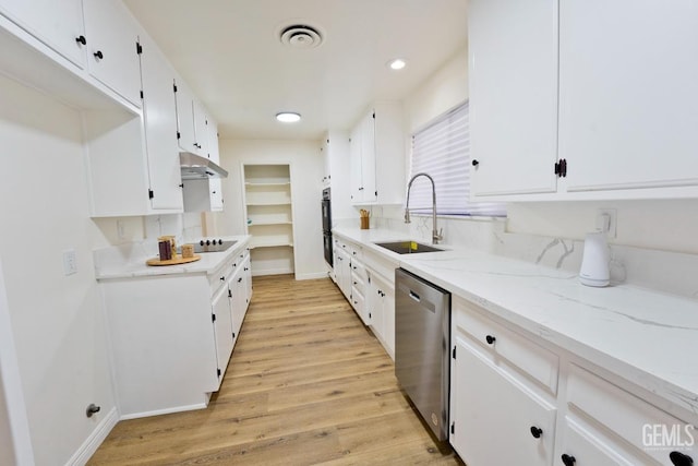 kitchen with under cabinet range hood, a sink, white cabinetry, visible vents, and stainless steel dishwasher