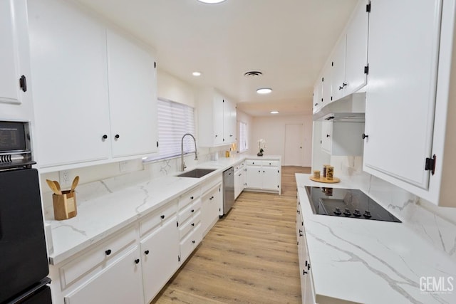 kitchen featuring light wood-style flooring, white cabinetry, a sink, under cabinet range hood, and black appliances