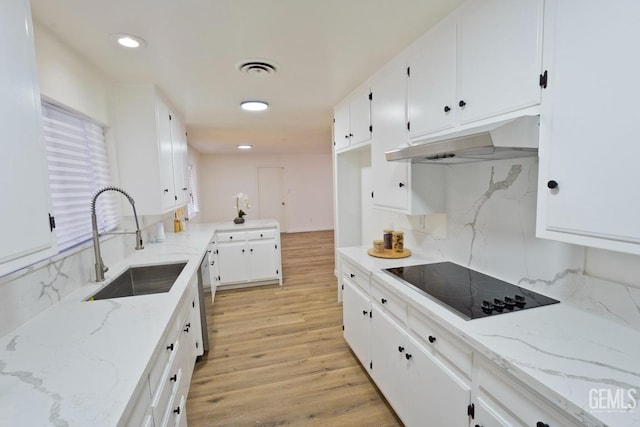 kitchen with light wood finished floors, black electric stovetop, stainless steel dishwasher, under cabinet range hood, and a sink