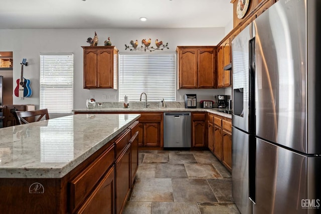 6315 Veronese Ct, Bakersfield, CA 93306 - kitchen with stainless steel appliances, stone finish floors, light stone countertops, brown cabinets, and recessed lighting