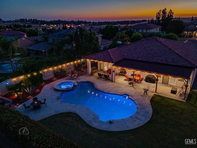 6315 Veronese Ct, Bakersfield, CA 93306 - pool at dusk featuring a patio area, a pool with connected hot tub, outdoor lounge area, and a fenced backyard