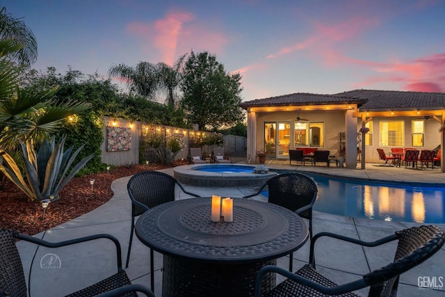 6315 Veronese Ct, Bakersfield, CA 93306 - pool at dusk with outdoor dining space, a fenced backyard, a patio, and a pool with connected hot tub