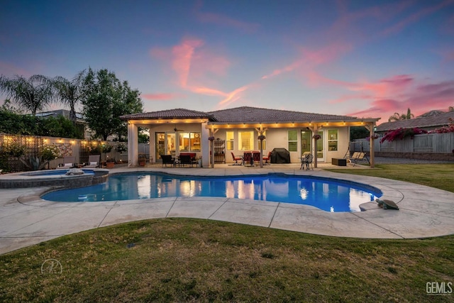 6315 Veronese Ct, Bakersfield, CA 93306 - pool at dusk with a fenced backyard, a patio, outdoor dining space, and a pool with connected hot tub
