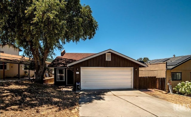 view of front of home featuring driveway, an attached garage, and fence