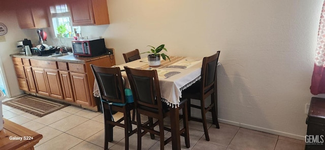 dining space with light tile patterned floors and baseboards