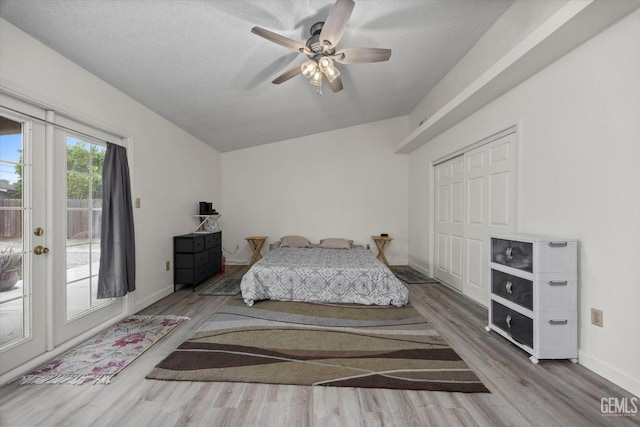 bedroom with ceiling fan, access to exterior, baseboards, wood finished floors, and vaulted ceiling