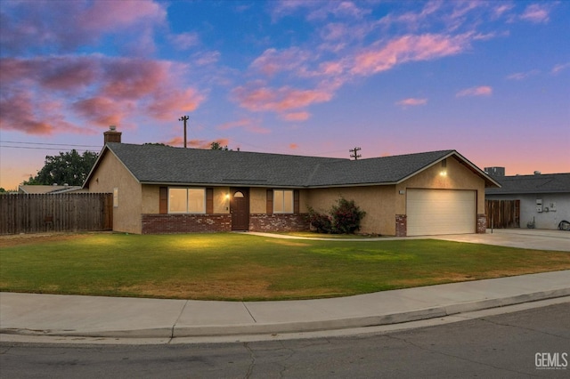 ranch-style home featuring a front yard, a garage, fence, concrete driveway, and stucco siding
