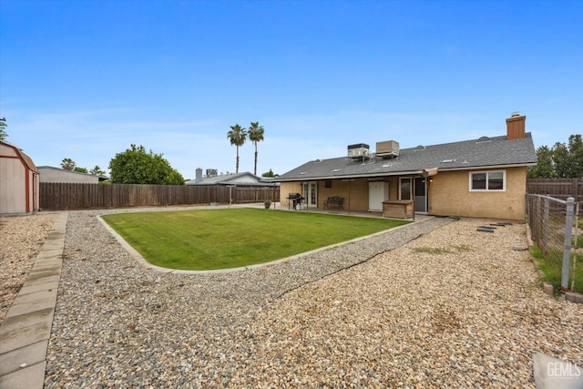 rear view of house with a patio, a fenced backyard, stucco siding, a chimney, and a lawn
